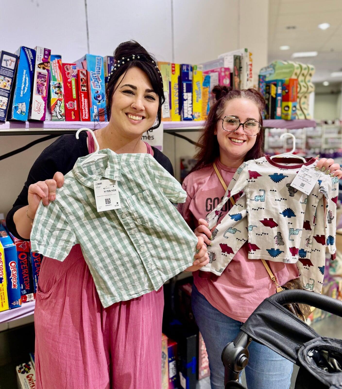 Mom and grandmother stand together, a few pieces of clothing in grandmom's hands, as they shop together for their family.